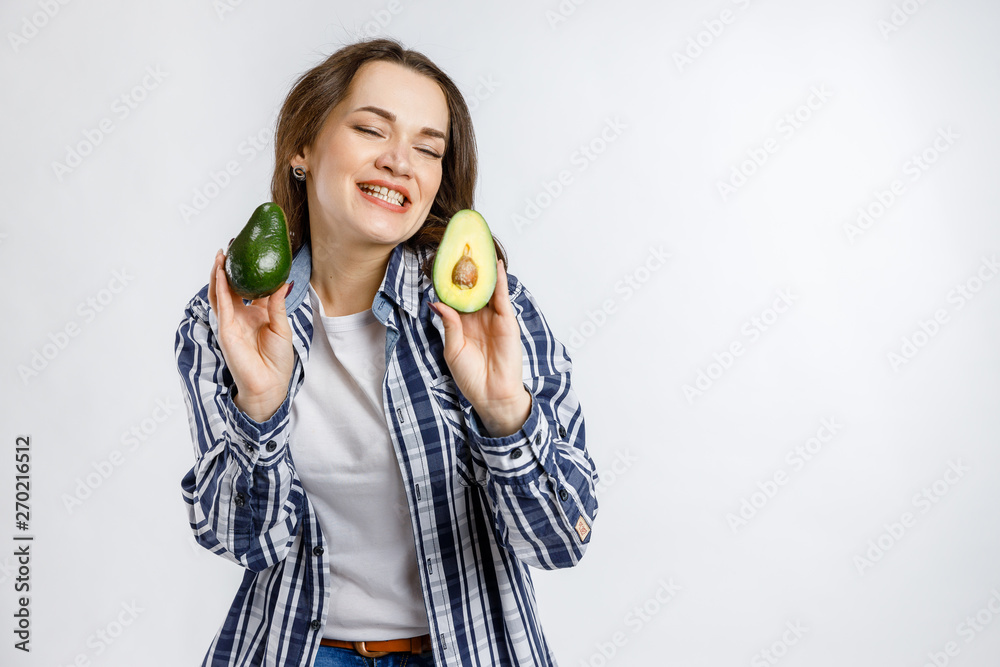 Young beautiful girl in plaid shirt holding orange on white background. Healthy food - vegetables, fruits and berries. Young beautiful girl in plaid shirt holding orange on white background. Healthy food - vegetables, fruits and berries.