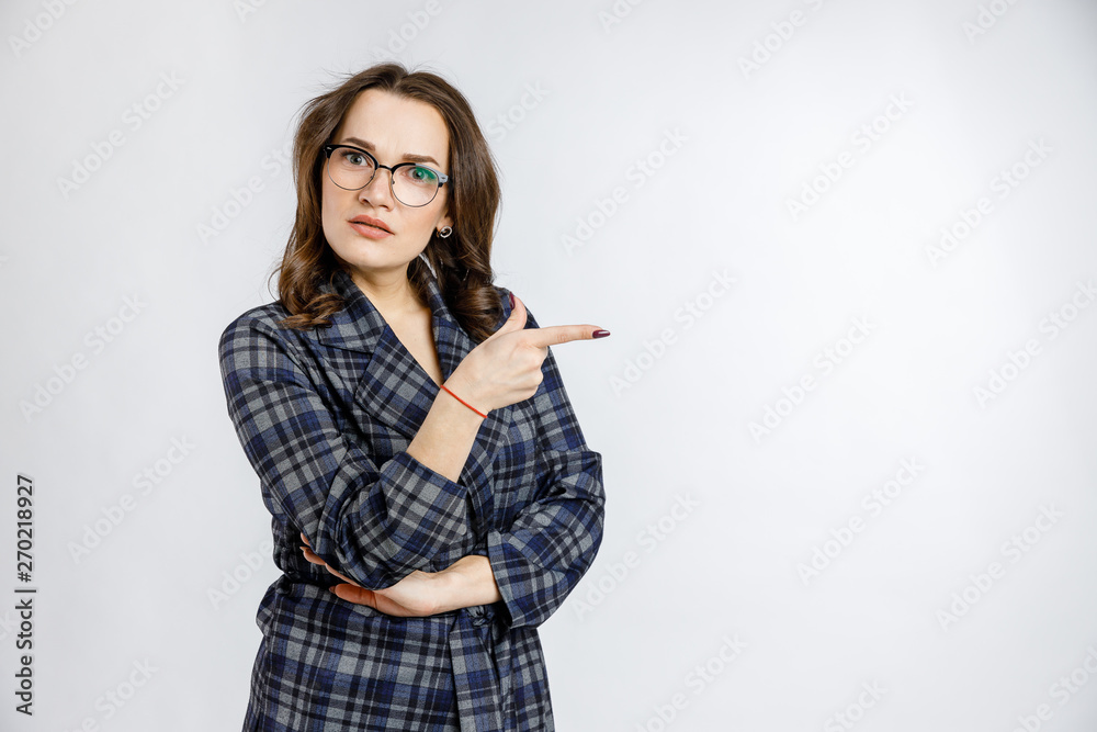 Young beautiful girl in a strict plaid suit posing on a white background. Emotions and feelings at work and office. Young beautiful girl in a strict plaid suit posing on a white background. Emotions and feelings at work and office.