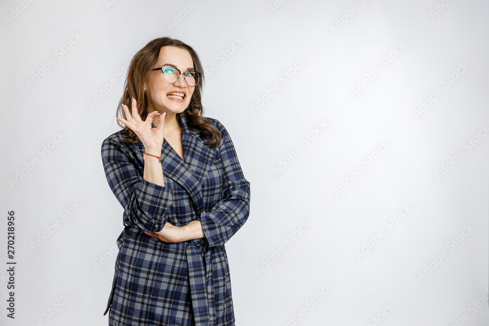 Young beautiful girl in a strict plaid suit posing on a white background. Emotions and feelings at work and office. Young beautiful girl in a strict plaid suit posing on a white background. Emotions and feelings at work and office.
