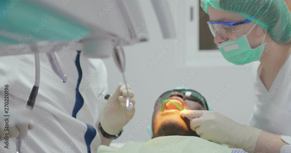 Dentist treats patient bad tooth with drill. Dentist treats patient bad tooth with drill.