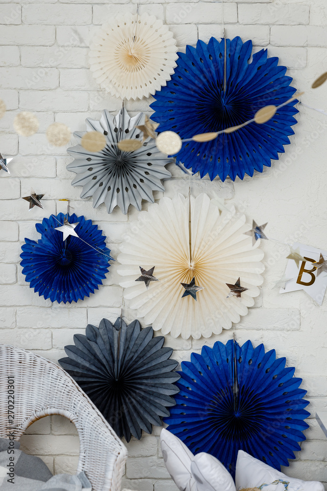 Obraz premium Birthday decorations with gifts, toys, garlands and figure for little baby party on a white bricks background. 