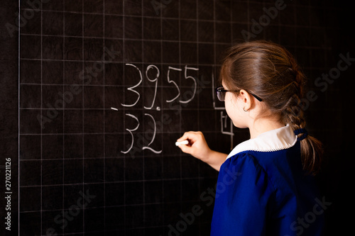 Photography Italian elementary school girl trying to solve a mathematics examples, making a