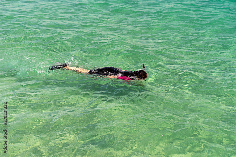 Female snorkeling in turquoise water