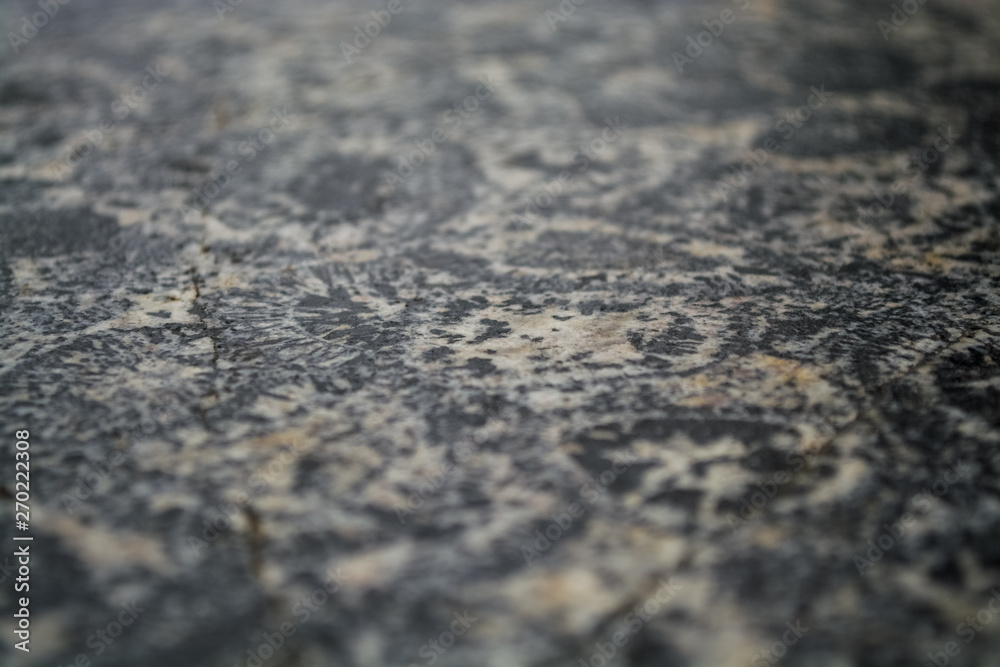 Background or texture from a gray stone with round spots and stains. Natural material. Glossy surface. Background or texture from a gray stone with round spots and stains. Natural material. Glossy surface.