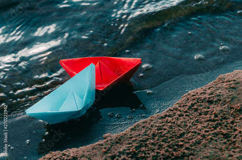 Small,red,paper boat is shipwrecked in a turbulent raging sea.