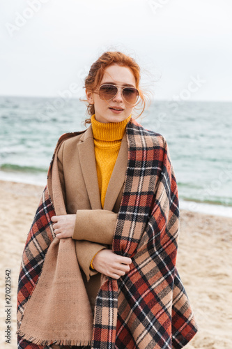 Lovely young redhead woman wearing autumn coat
