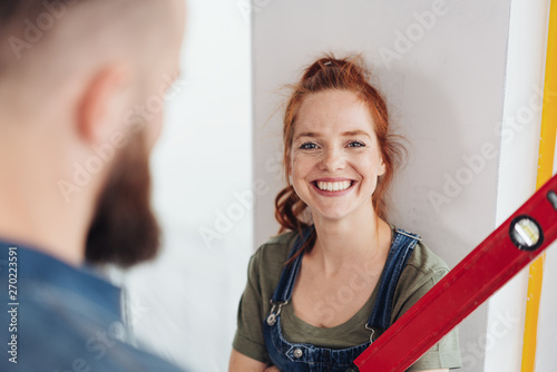 Obraz na plátně Happy smiling redhead woman in dungarees