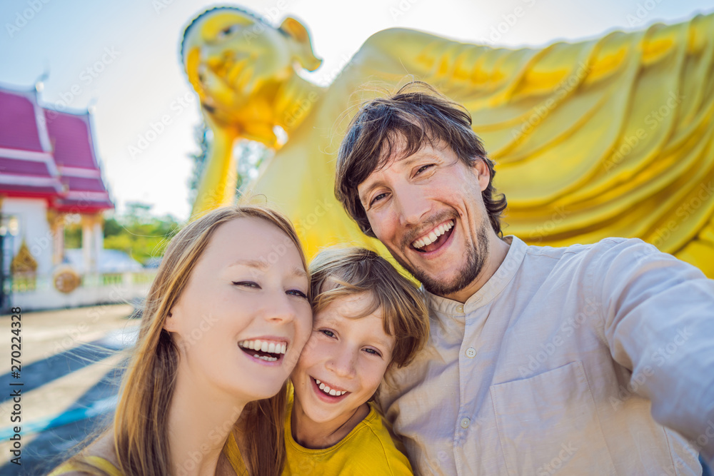 Happy tourists mother, father and son on background ofLying Buddha statue Happy tourists mother, father and son on background ofLying Buddha statue