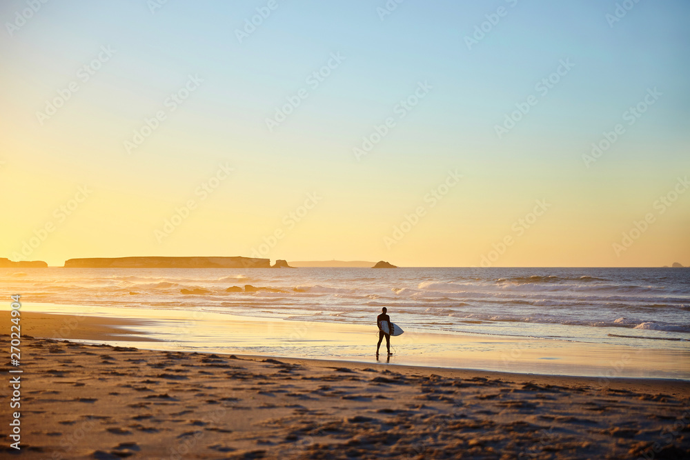 surfer walks on the beach