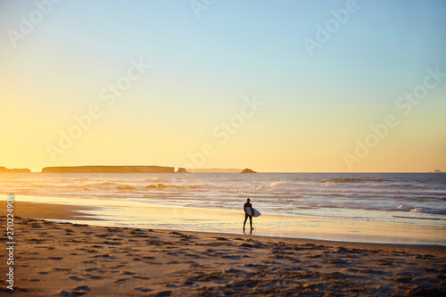 surfer walks on the beach