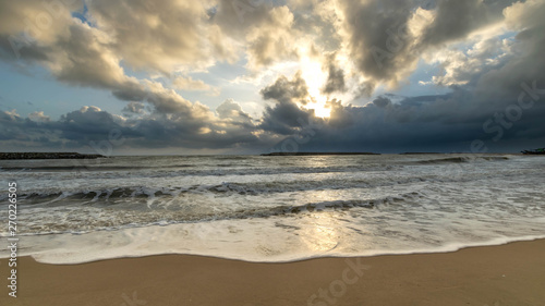 Sand  sea and clouds at sunrise