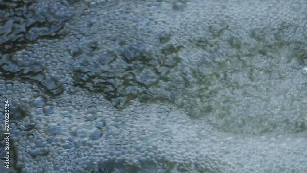 Bubbles sparkling in fresh river water, extreme close up of fast-moving drops of air with beautiful bokeh, energy and dynamic movement, slow motion shot. Bubbles sparkling in fresh river water, extreme close up of fast-moving drops of air with beautiful bokeh, energy and dynamic movement, slow motion shot.