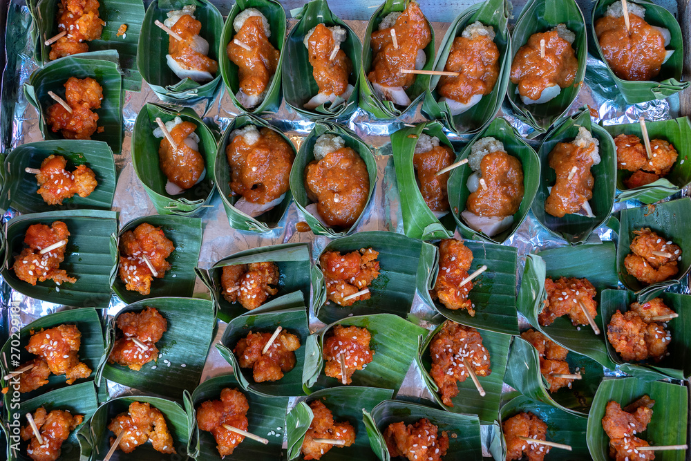 Traditional indonesian snack in green palm leaves . Close up. Asian food background, buffet table