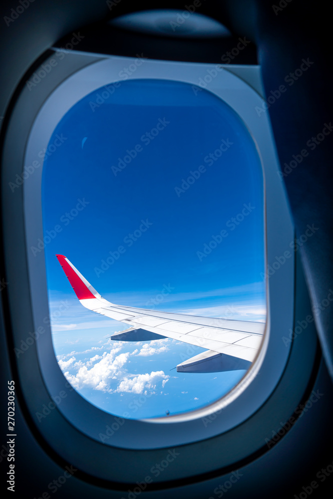 Clouds and sky as seen through window of an aircraft Clouds and sky as seen through window of an aircraft