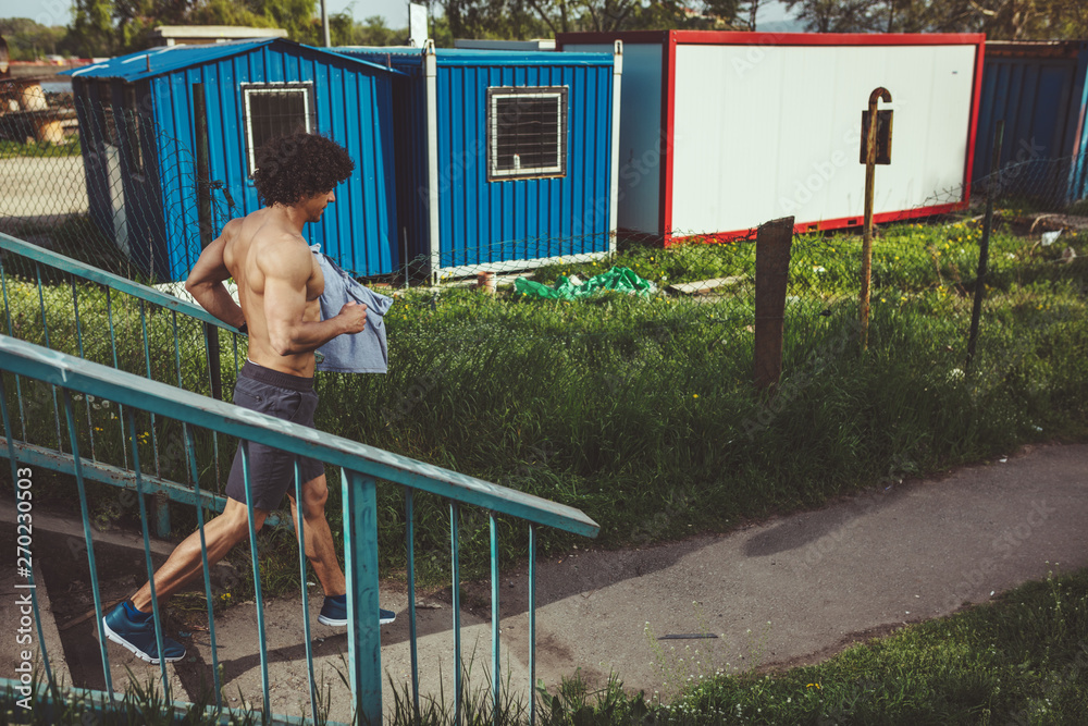 Fototapeta premium Muscular Man Running Down The Stairs