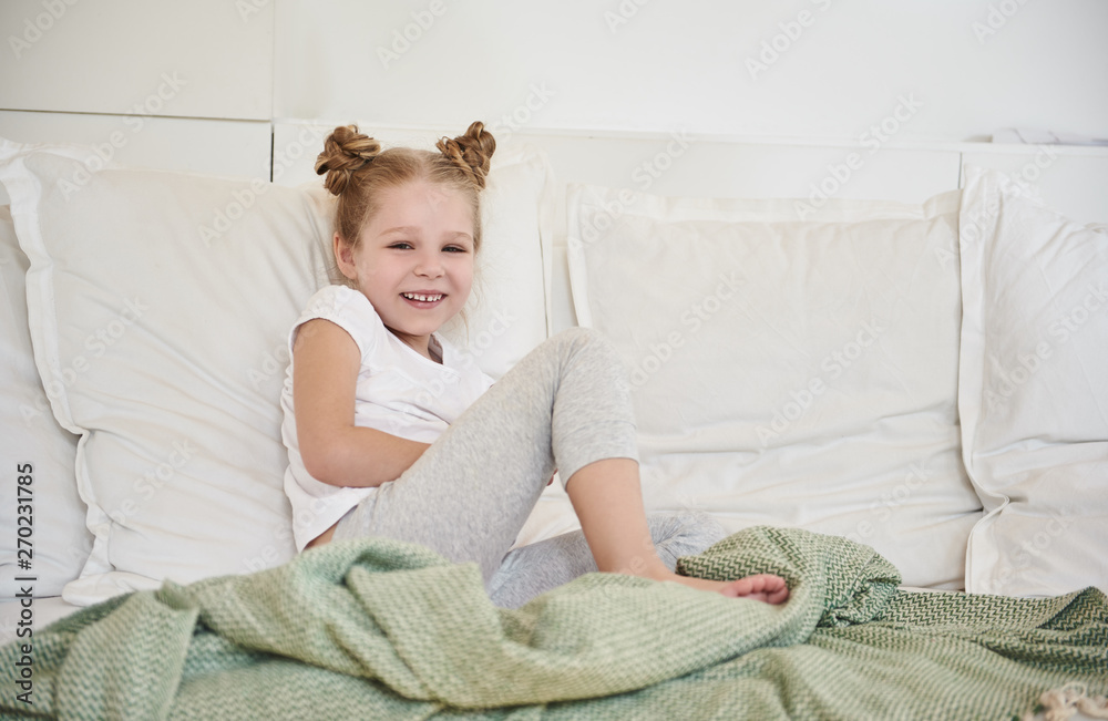Cheerful little girl using sitting on couch at home Cheerful little girl using sitting on couch at home