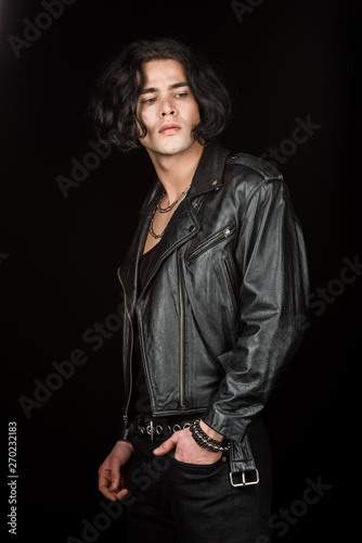 handsome man standing with hand in pocket isolated on black