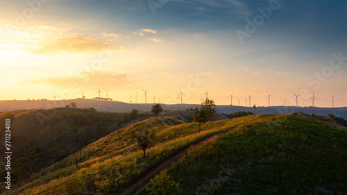 Mountain valley with wind turbines during sunrise. Natural summer landscape. 