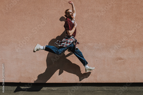 Happy excited hipster man jumping high outdoor
