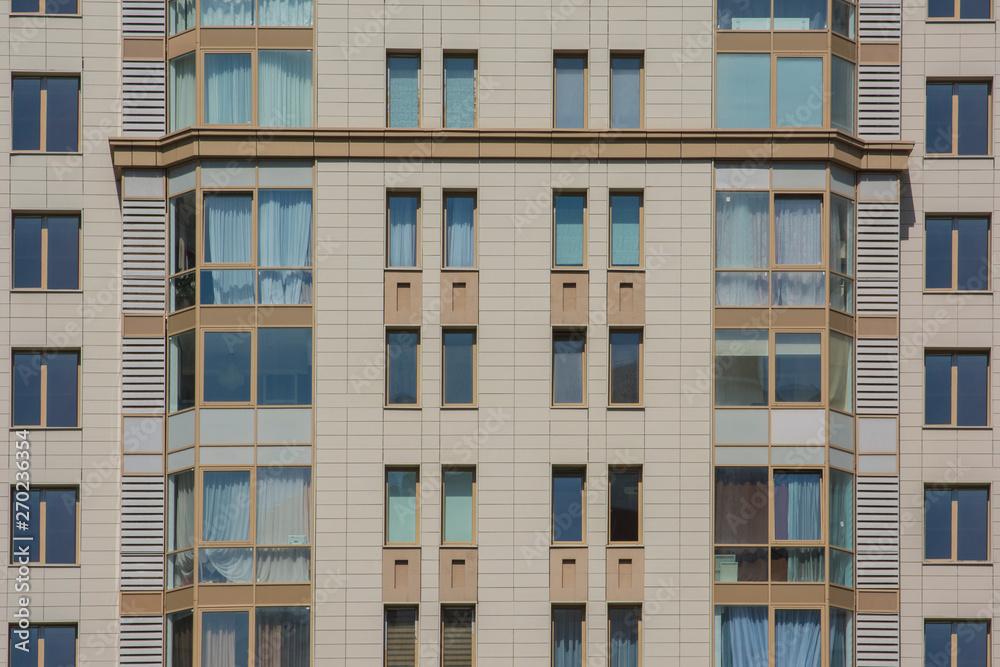 Facade of a multi-storey apartment building against the blue sky