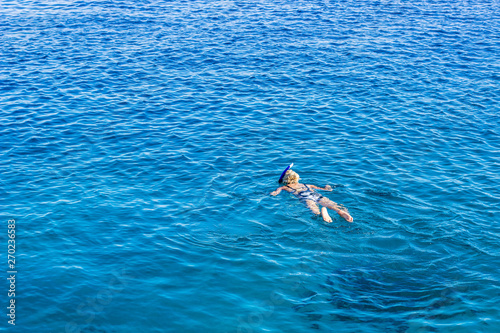 sexy Ukrainian girl floating on blue water calm background surface, red sea summer resort vacation time, wallpaper pattern photography with empty copy space for text 