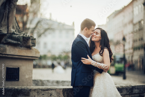 Lovely wedding couple kissing in the city.