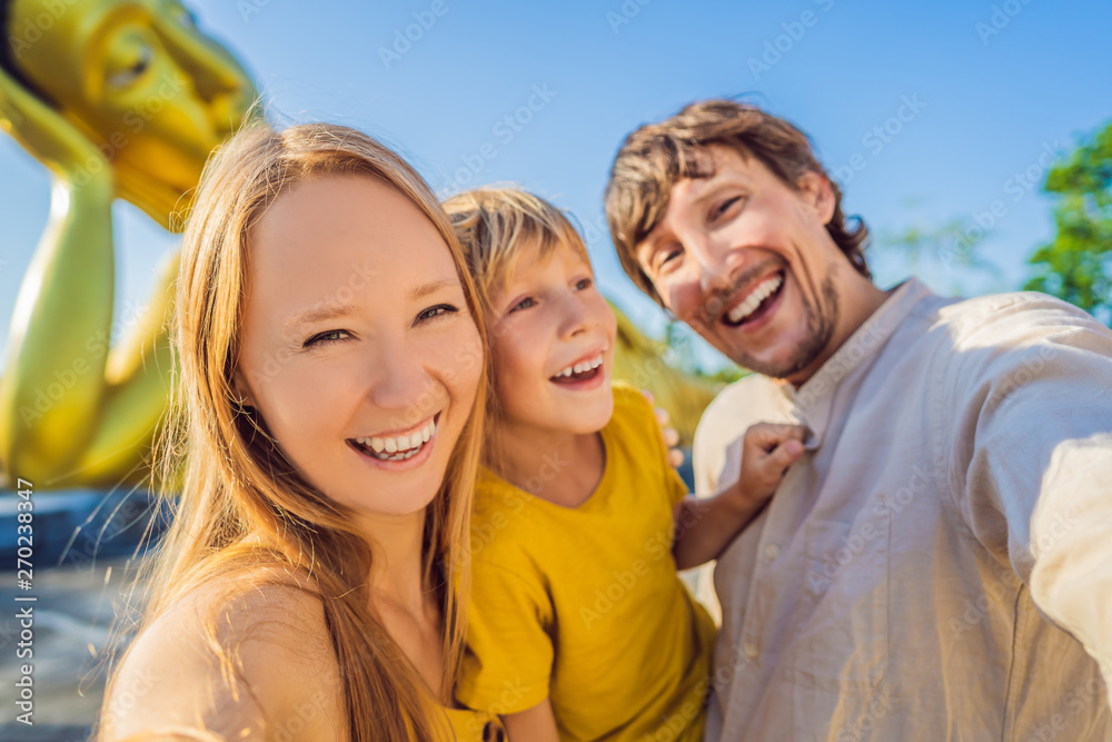 Happy tourists mother, father and son on background ofLying Buddha statue Happy tourists mother, father and son on background ofLying Buddha statue