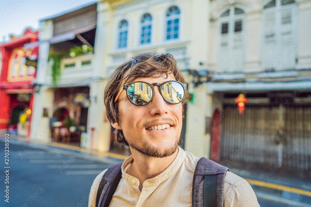 Man tourist on the Street in the Portugese style Romani in Phuket Town. Also called Chinatown or the old town Man tourist on the Street in the Portugese style Romani in Phuket Town. Also called Chinatown or the old town