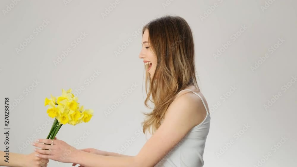 Happy woman smells flowers and smiles slow motion Happy woman smells flowers and smiles slow motion
