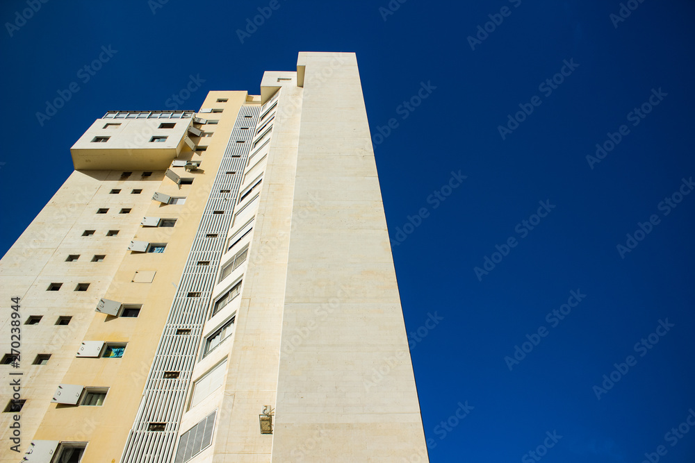 high building tower foreshortening from below on south city street perspective photography on saturated blue sky background with empty copy space for text high building tower foreshortening from below on south city street perspective photography on saturated blue sky background with empty copy space for text