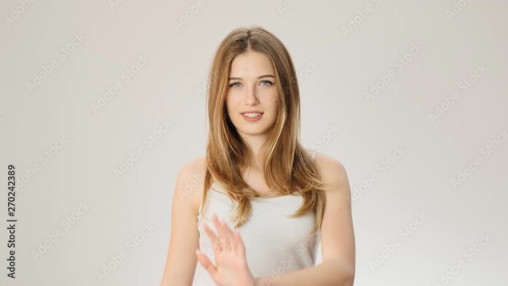 Excited attractive young woman singing out loud and smiling standing over grey wall slow motion Excited attractive young woman singing out loud and smiling standing over grey wall slow motion