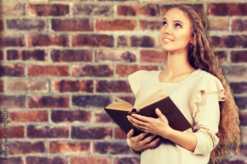 Man holding old bible book on brick wall background