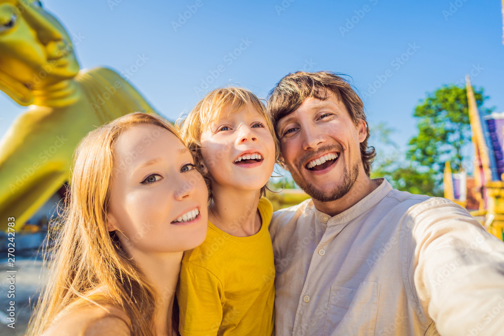 Happy tourists mother, father and son on background ofLying Buddha statue Happy tourists mother, father and son on background ofLying Buddha statue