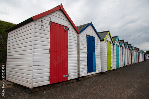 Colorful beach huts with moody sky on Goodrington sands beach, Devon, England UK © Stephen Davies