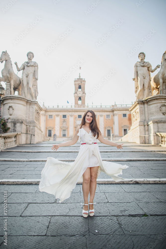 young beautiful girl in white clothes walks in Rome in Italy at sunset