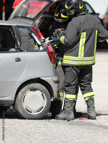 firefighters with shears open a car after the road accident