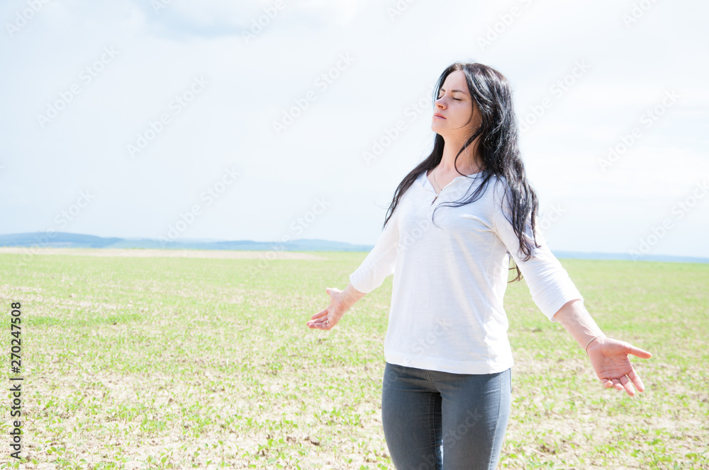 standing woman with arms outstretched and praying to God. Glorifies God. Against the backdrop of clouds and sky. standing woman with arms outstretched and praying to God. Glorifies God. Against the backdrop of clouds and sky.