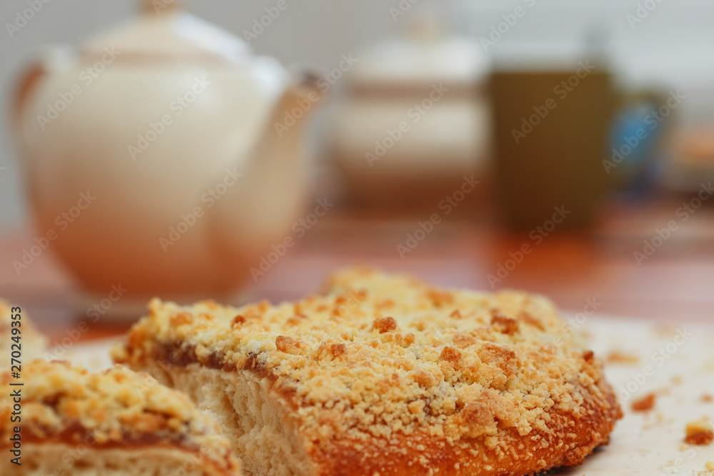 Sweet sand tart with apricot jam. Cut into pieces, lying on a board with a kettle in the background Sweet sand tart with apricot jam. Cut into pieces, lying on a board with a kettle in the background
