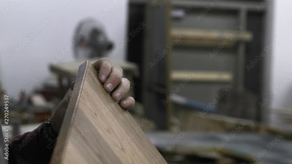 A carpenter inspects a piece of wood for imperfections A carpenter inspects a piece of wood for imperfections