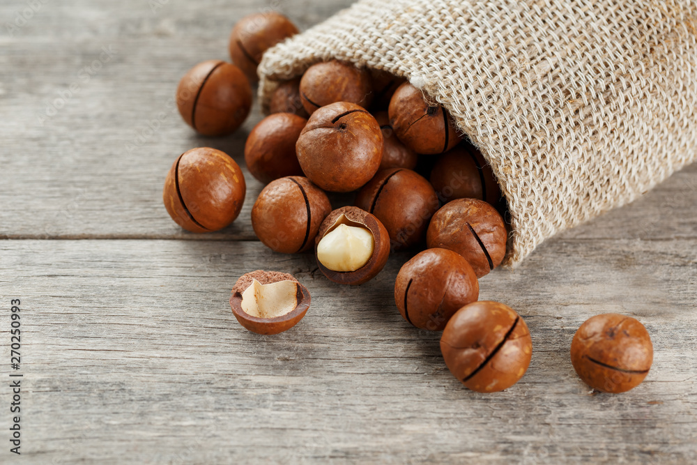Macadamia nut on a wooden table in a bag, closeup, top view Macadamia nut on a wooden table in a bag, closeup, top view
