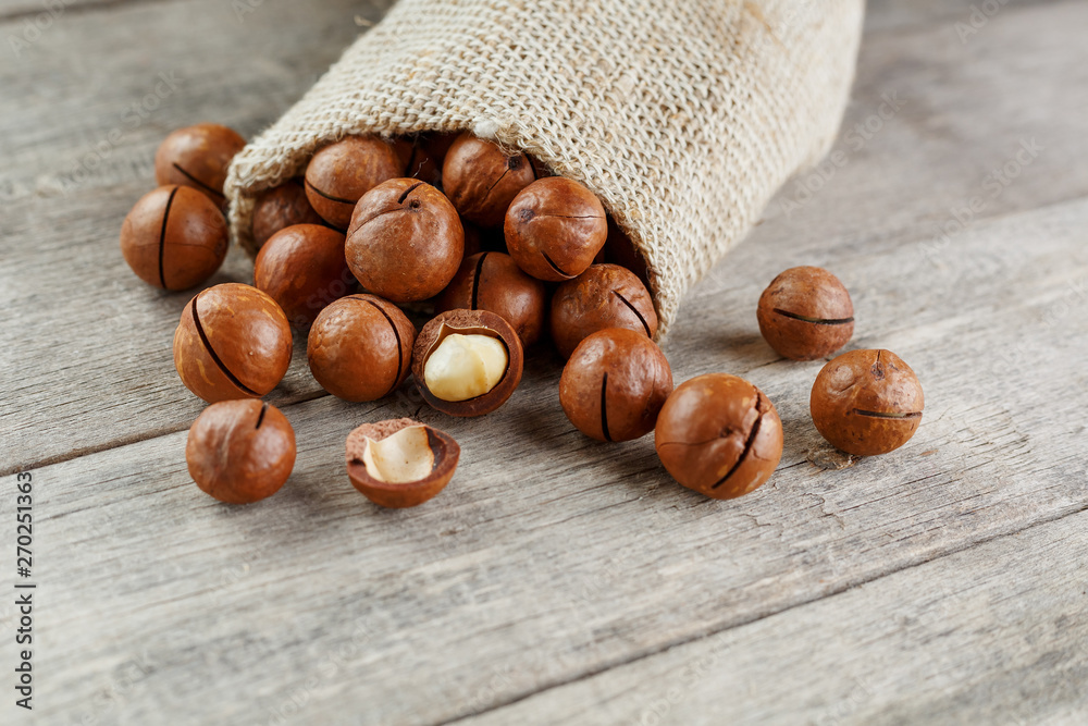 Macadamia nut on a wooden table in a bag, closeup, top view Macadamia nut on a wooden table in a bag, closeup, top view