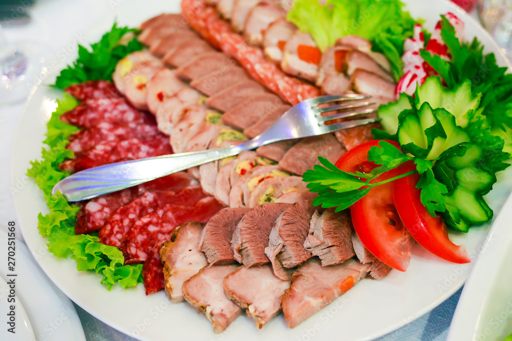 a plate of ham, bacon, salami and sausages. Meat platter. a plate of ham, bacon, salami and sausages. Meat platter.