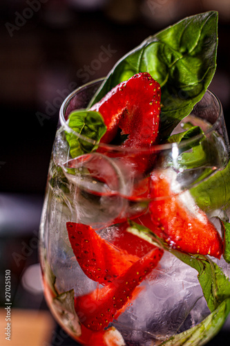 refreshing lemonade with fresh strawberry and basil on glass close up