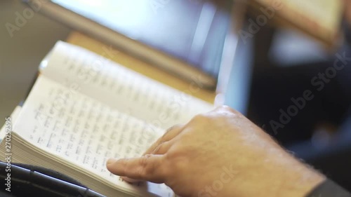 Old Man Hand on Tehillim Book. Turning Page and Read tehillim in King David Grave. Jerusalem, Israel. photo