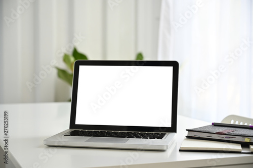 Fototapeta Naklejka Na Ścianę i Meble -  Laptop empty screen on white table with notebook paper.