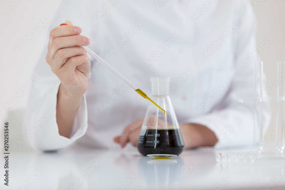 Scientist tearing the CBD oil with a precise dropper from a bowl into a tube Scientist tearing the CBD oil with a precise dropper from a bowl into a tube