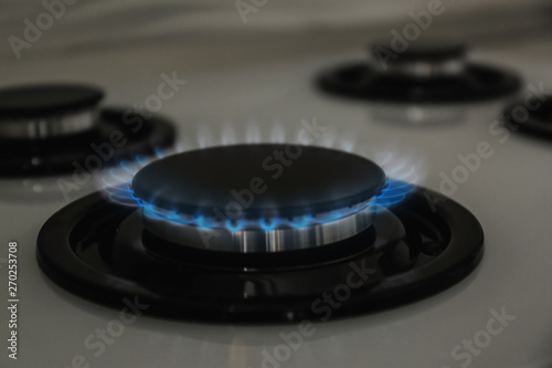 Gas burner with blue flame on modern stove, closeup © New Africa
