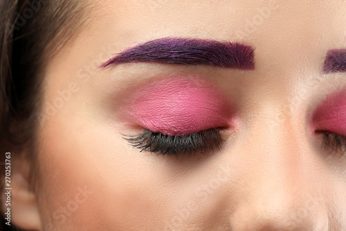 Young woman with dyed eyebrows and creative makeup  closeup