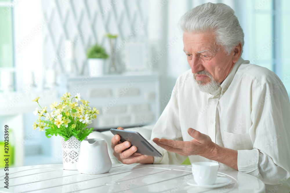 Portrait of thoughtful senior man using tablet Portrait of thoughtful senior man using tablet