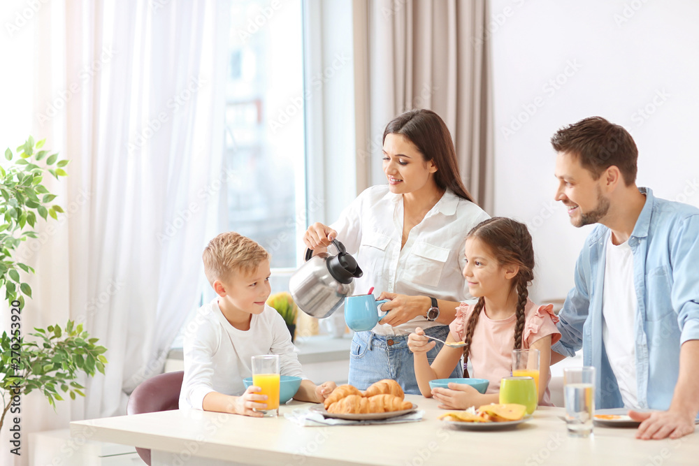 Happy family having breakfast together in kitchen Happy family having breakfast together in kitchen